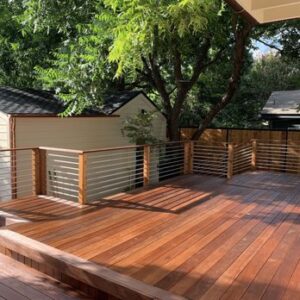 A wooden deck with benches and a tree.