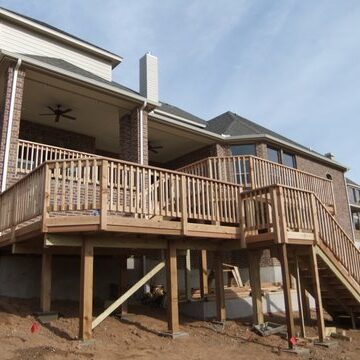 A large wooden deck with stairs leading to the top of it.