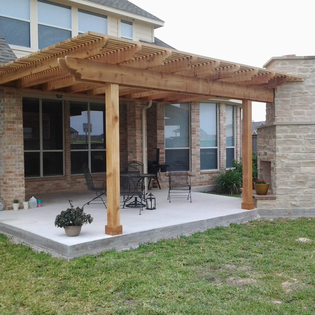 A patio with a wooden pergola and concrete slab.