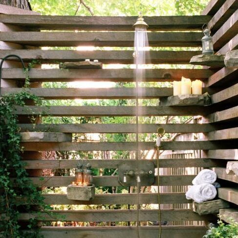 A wooden fence with a shower head on it.